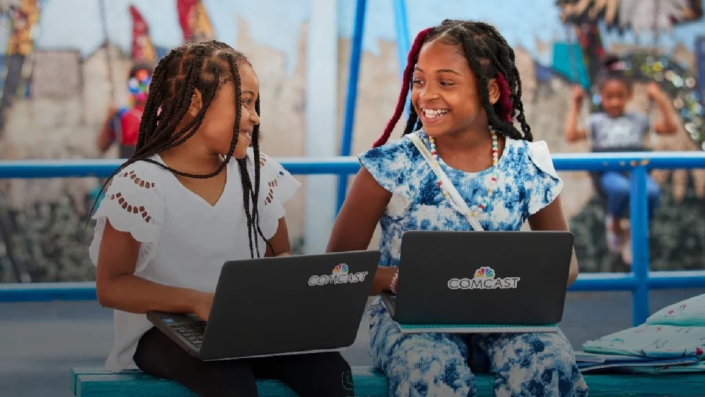 Comcast affordable connectivity program two girls on laptops.